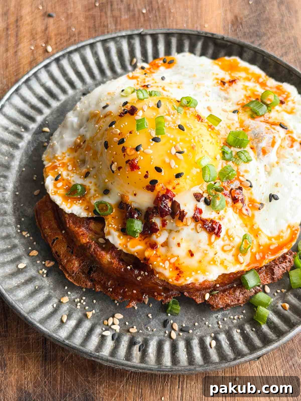 Crispy Hash Brown Waffles Recipe 3 crispy potato waffle topped with a half fried egg and served on a plate
