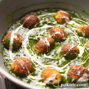 The Healthy Palak Paneer Kofta Curry in a pan with cream drizzled on top