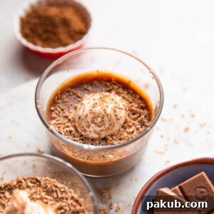 Paneer chocolate pudding topped with whipped cream and cocoa powder in a dessert bowl