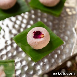 rose kacha golla garnished with dried rose petal and served on a leaf square