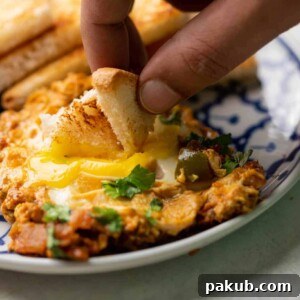 A slice of bread being dipped into the egg yolk