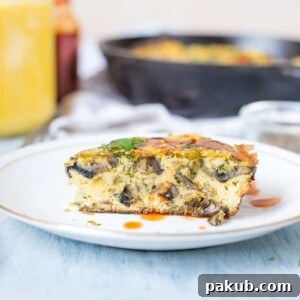 One Pan Indian Masala Omelette Frittata drizzled with sriracha and served on a white plate.