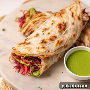 2 anda parathas served on a platter with green chutney