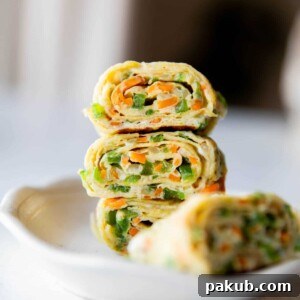 a close up shot of korean omelette roll stacked one on top of the other in a white bowl