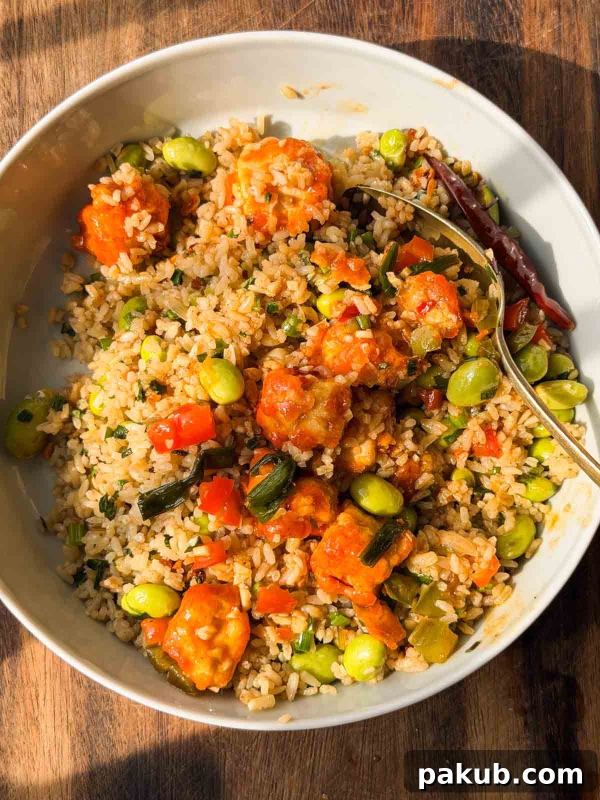 Garlic Edamame Rice Bowl with Extra Protein 3 edamame garlic rice topped with teriyaki chicken and served in a white bowl