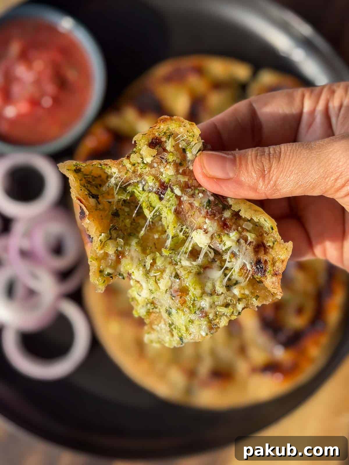 High Protein Stuffed Broccoli Paneer Paratha Recipe 3 a person holding an opened broccoli paratha to showcase it's the stuffing inside